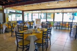a dining room with tables and chairs with yellow table cloth at Puebla Inn Express in Puebla