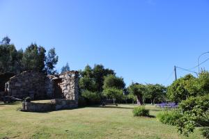 an old stone building in a grassy field at Casa Valdamor in Meaño