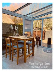 a wooden table and chairs on a patio at Hotel Pension garni Haus am Strand 2 in Norddeich