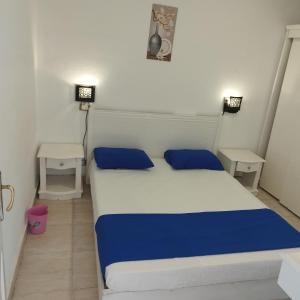 1 dormitorio con 1 cama blanca y azul y 2 mesas en Juliee House-Criss Resort-Naama Bay en Sharm El Sheikh
