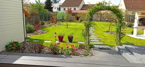 a backyard with a garden with flowers and an arbor at Chambre d'hôtes in Le Mans