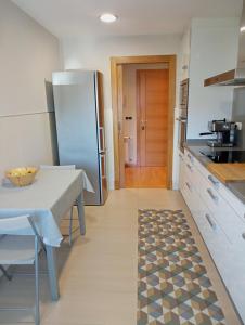 a kitchen with a table and a refrigerator at A Devesa in Redondela