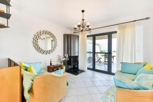 a living room with two chairs and a chandelier at VILLAGE CLUB 27 in Nea Fokea