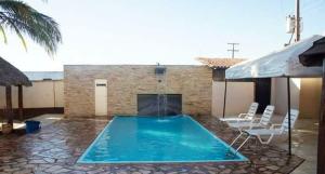 a swimming pool with two chairs and a fountain at Plumas hotel in Tucuma