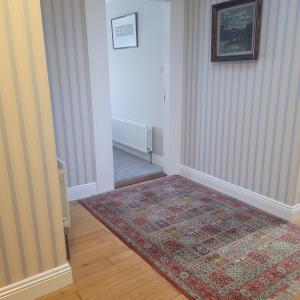 a hallway with a rug on the floor and a door at Dun Maeve Guesthouse in Westport