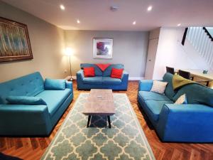 a living room with blue couches and a table at Knockreagh Farm Cottages, Callan, Kilkenny in Kilkenny