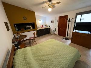 a bedroom with a bed and a table and a kitchen at Linda casa en Barra de Carrasco in Montevideo