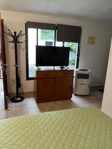 a bedroom with a flat screen tv on a dresser at Linda casa en Barra de Carrasco in Montevideo