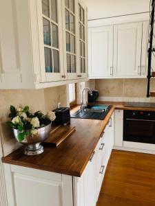 a kitchen with white cabinets and a bowl of flowers on a counter at Apartamenty Euphoria in Gołdap