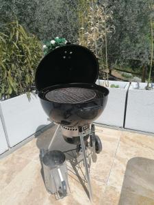 a black grill sitting on top of a patio at Chambre d'hôtes et Spa en Luberon in Volx