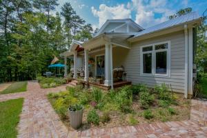 Casa blanca pequeña con patio de ladrillo en Firefly Lake House, en Northport