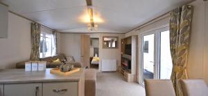a living room with a kitchen and a living room with a couch at Fantastic Family 3-Bed static Caravan cooper bea in Colchester
