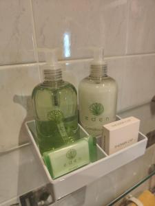 two bottles of soap on a shelf in a bathroom at The Dial inn in Lamphey