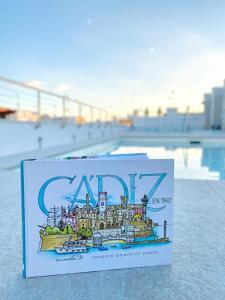 ein Buch mit einem Bild einer Stadt darauf in der Unterkunft Goodnight Cádiz Apartments in Cádiz