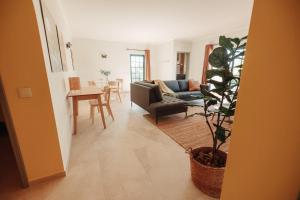 a living room with a couch and a plant at Casa Velha Apartments - Adults friendly in Albufeira