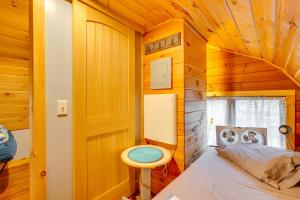 a small bedroom with a bed in a wooden cabin at Lime Lake Cottage with Lakefront Deck and Dock! 
