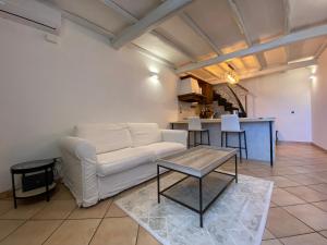 een woonkamer met een witte bank en een tafel bij Appartamento Vista Lago in Anguillara Sabazia