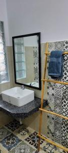 a bathroom with a sink and a mirror at Urban Farmhouse in Siem Reap