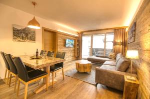 uma sala de estar com uma mesa e um sofá em Alpin & Seeresort Top 14 - by Alpen Apartments em Zell am See