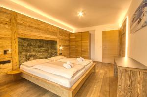 a bedroom with a large bed with wooden walls at Alpin & Seeresort Top 14 - by Alpen Apartments in Zell am See