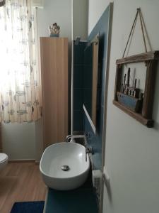 ein Badezimmer mit einem weißen Waschbecken und einem Spiegel in der Unterkunft Halfway Private Room - Casa all'Italiana in Florenz