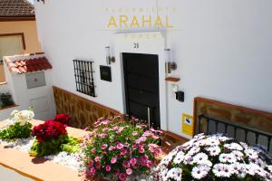 龍達的住宿－ALOJAMIENTO ARAHAL - RONDA，门前的桌子上放着鲜花