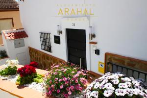 une table avec des fleurs devant une porte dans l'établissement ALOJAMIENTO ARAHAL - RONDA, à Ronda