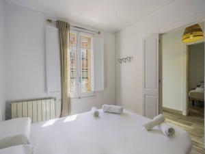 una camera bianca con un grande letto bianco e uno specchio di Fantástica casa reformada en Badalona a Badalona