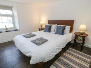 a bedroom with a large white bed with two pillows on it at Tinners in Gunnislake