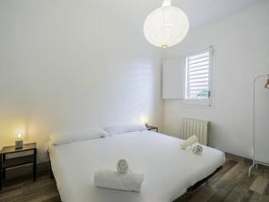 Un dormitorio blanco con una cama blanca y una ventana en Fantástica casa reformada en Badalona en Badalona
