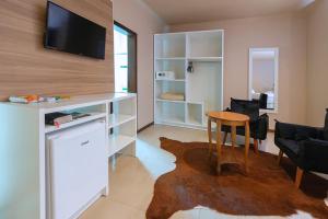 a living room with a desk and a table and chairs at Hotel Fazenda Dona Francisca in Joinville