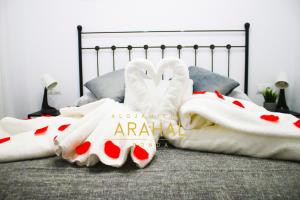 Una cama con mantas blancas y almohadas. en ALOJAMIENTO ARAHAL - RONDA, en Ronda