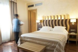 een man in een hotelkamer met een groot bed bij Hotel Duran in Figueres