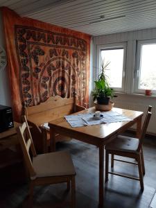 einen Esstisch mit 2 Stühlen und einem Teppich an der Wand in der Unterkunft Ferienwohnung Namaste in Langenargen