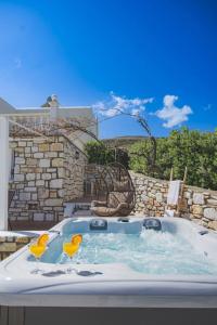 a jacuzzi tub with two yellow glasses in it at Irini's house with Jacuzzi in Dhragoulás