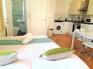 two beds in a small kitchen with a table and a kitchen at Excellent Studio flat in London in London