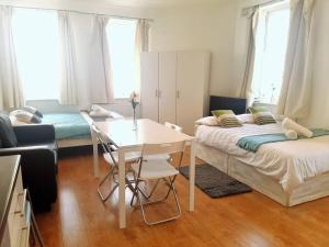 a living room with two beds and a table at Excellent Studio flat in London in London
