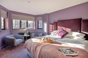 a bedroom with purple walls and a bed and chairs at Finest Retreats - Castle House Nottingham - Luxurious Hot Tub Stay in Nottingham