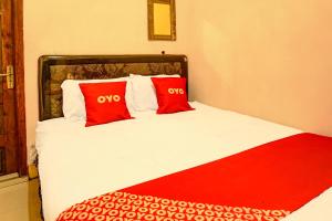 a bedroom with a bed with two red pillows at OYO Life 92499 Bagas Homestay Wonokitri in Pasuruan