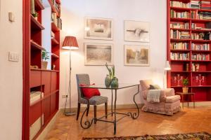 a room with a table and chairs and bookshelves at EXCLUSIVA CASA EN EL CENTRO HISTORICO de SEVILLA in Seville
