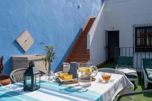 una mesa con comida y bebidas en una pared azul en EXCLUSIVA CASA EN EL CENTRO HISTORICO de SEVILLA en Sevilla