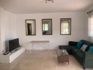 a living room with a couch and a tv at Royal Park Guesthouse in Corralejo