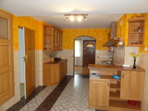 cocina con paredes amarillas y armarios de madera en Agroturystyka Pod Brzozami, en Karsibór