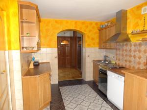 cocina con paredes amarillas y armarios de madera en Agroturystyka Pod Brzozami, en Karsibór