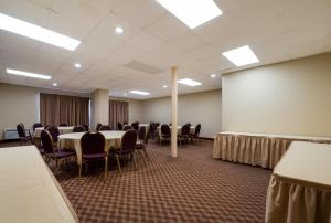 una sala de conferencias con mesas, sillas y una pantalla en Red Roof Inn and Suites Newark - University, en Newark