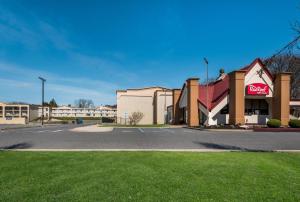 un edificio con un cartel de coca cola en un estacionamiento en Red Roof Inn and Suites Newark - University, en Newark