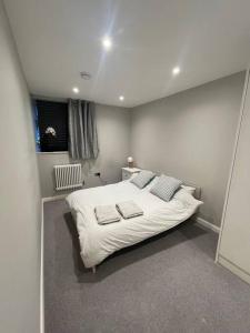 Marvellous New Build 2 Bed Flat - 1 Ophelia Court في إبسوم: غرفة نوم عليها سرير وفوط