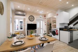 ファロにあるCasa na Travessa 2の木製のテーブルと椅子のあるキッチンとダイニングルーム