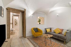 un soggiorno con divano e sedia gialla di Casa na Travessa 2 a Faro