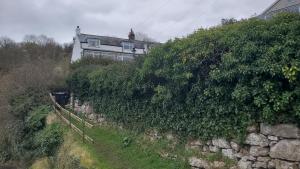a house on a hill next to a stone wall at A View With A Room in Penrhyn Bay +44 photos